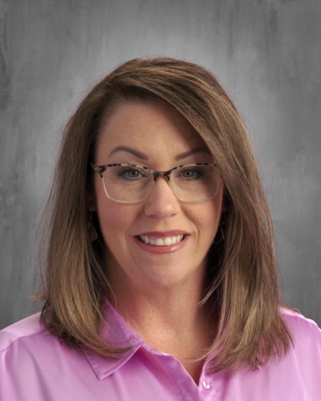 Virtual School Principal headshot with glasses, brown hair, and a pink blouse.