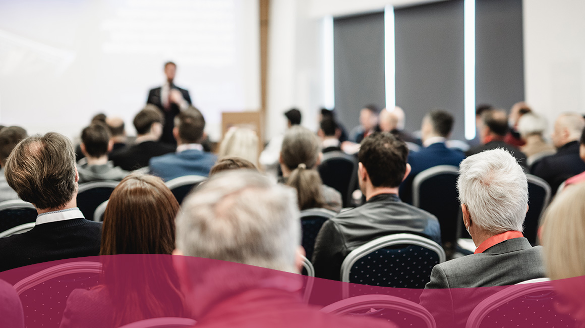 Group of people at a conference listening to a speaker