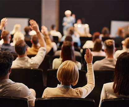 A group of people at DLAC - raising their hands to discuss online learning in the K-12 space.